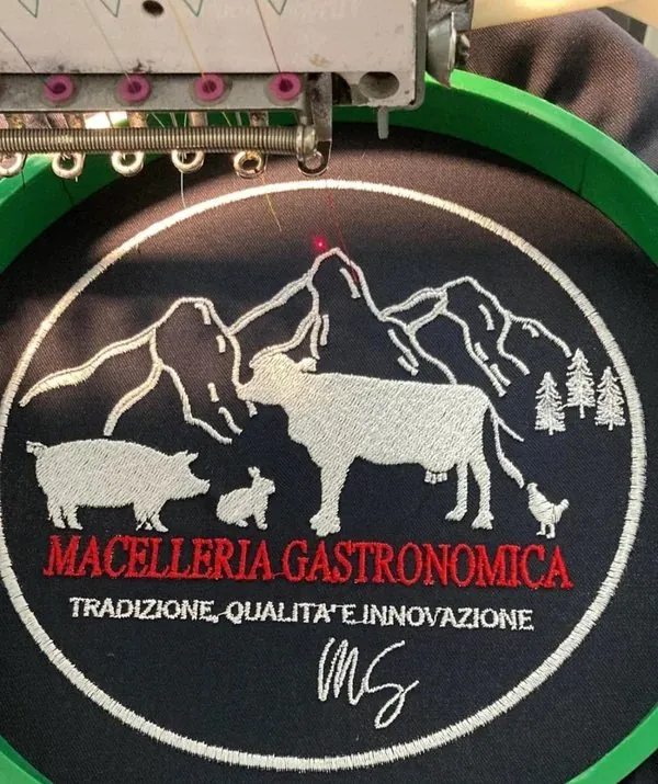 Macchina da ricamo al lavoro su un logo